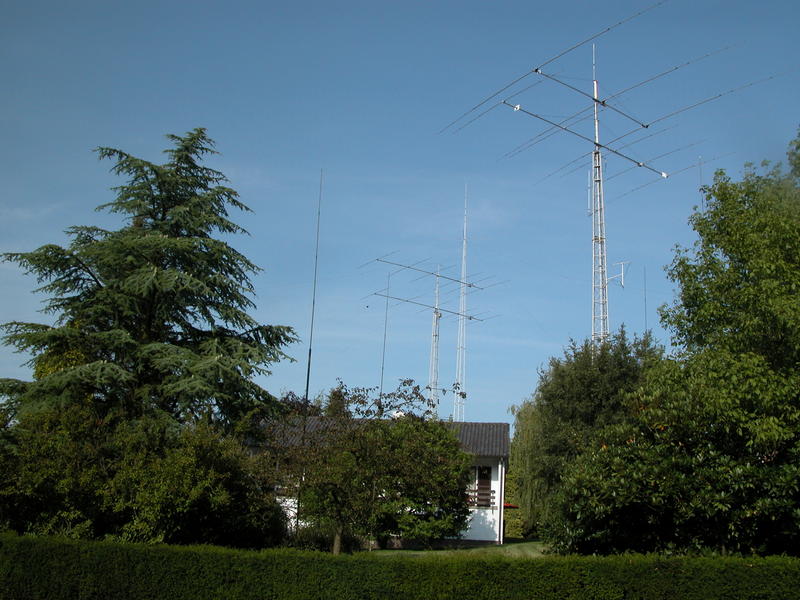 View from the street of the towers with the single band home-made yagis at ON4UN, as well as the 160m quarter-wave vertical.